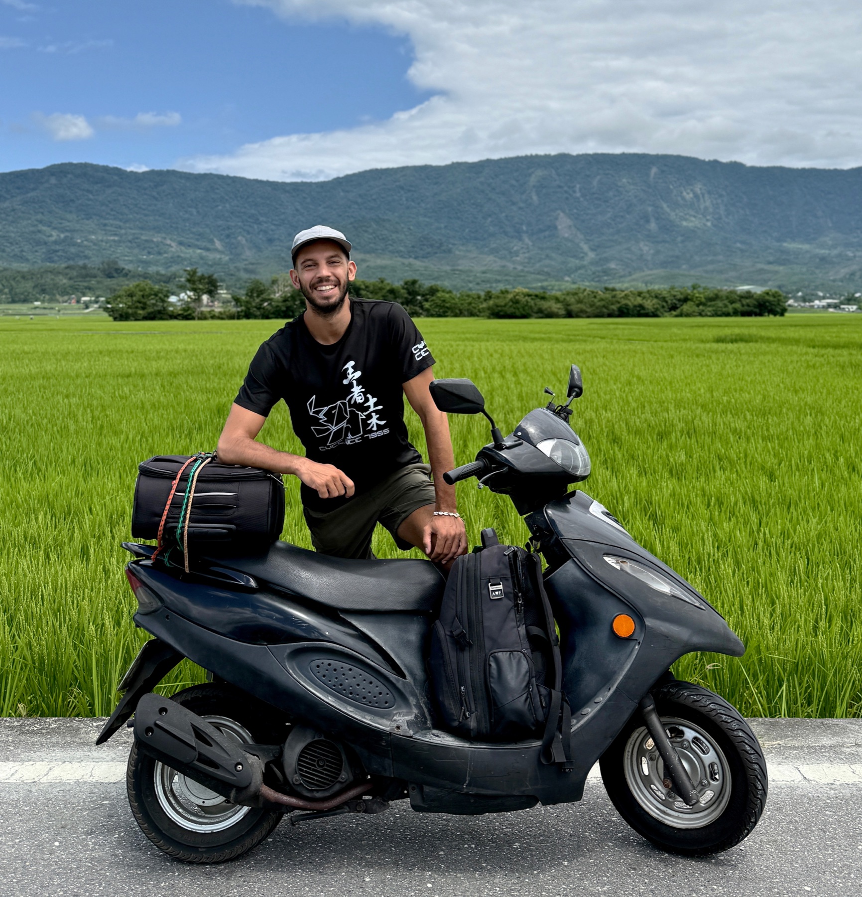 Filippo with his loaded scooter beside a rice field, Taiwan